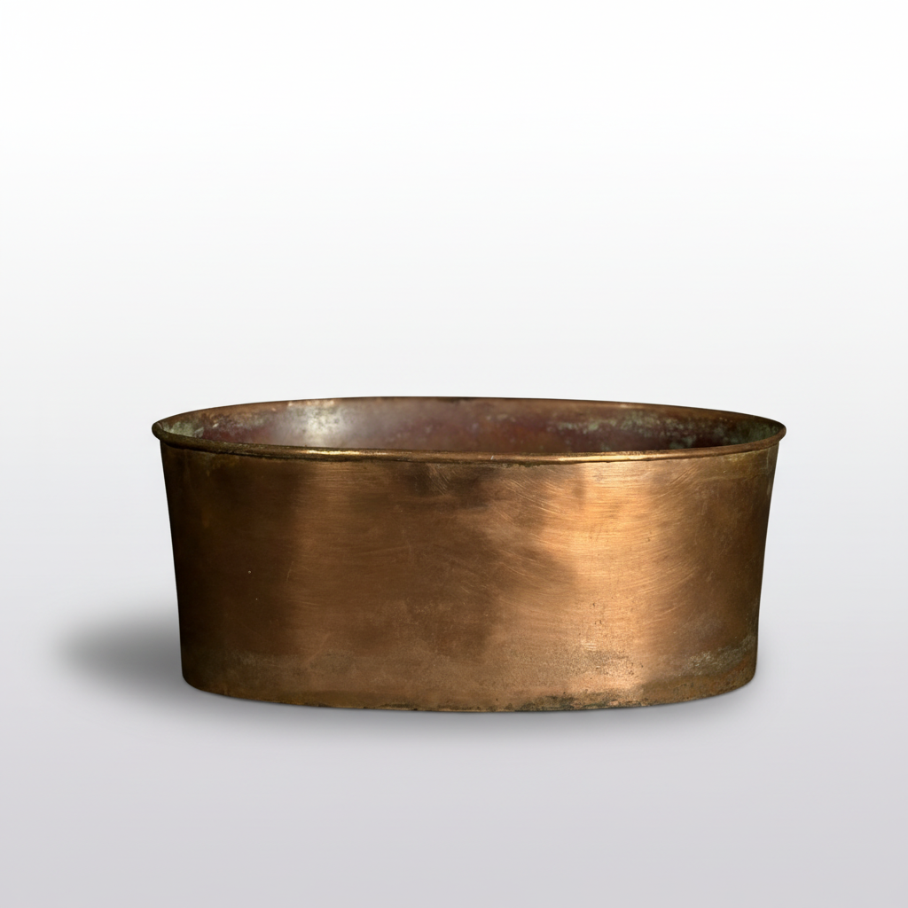 A rustic oval copper pot or planter with a weathered, patinated surface, set against a dark, textured background.