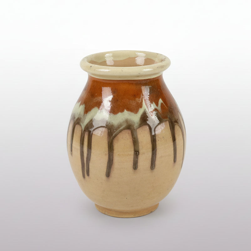 A small French glazed stoneware jar with a tan body and a rich brown drip glaze.