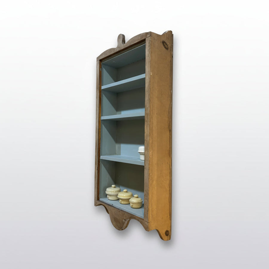 Wooden wall shelf with decorative items against a white wall