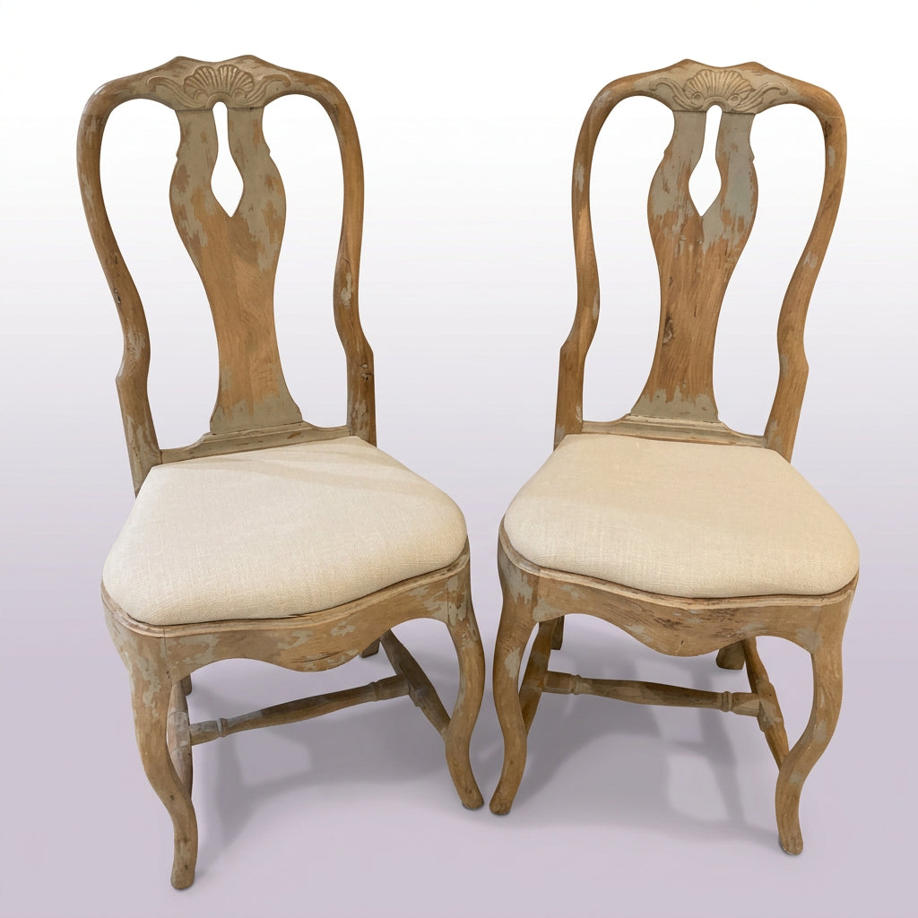 A pair of beige and white upholstered side chairs with wooden legs, displayed against a grey background.