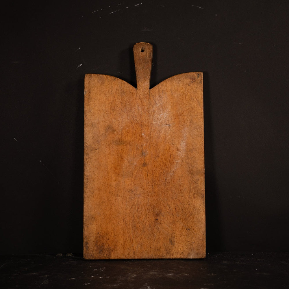 Wooden cutting board with a handle on a black background
