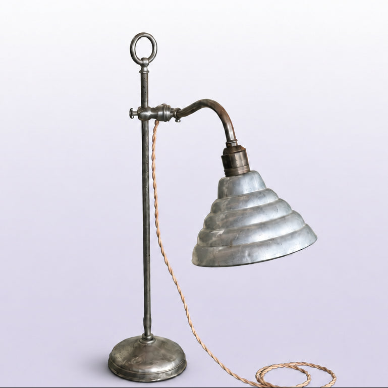 Vintage-style metal lamp with a ribbed glass shade on a wooden surface.
