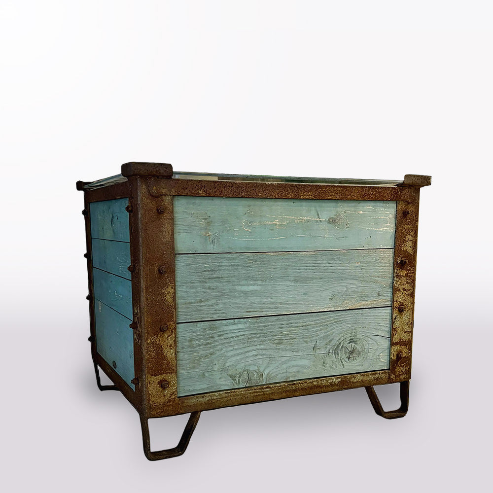 Vintage-style dresser with wooden frame and blue-painted drawers in a room with decorative elements.