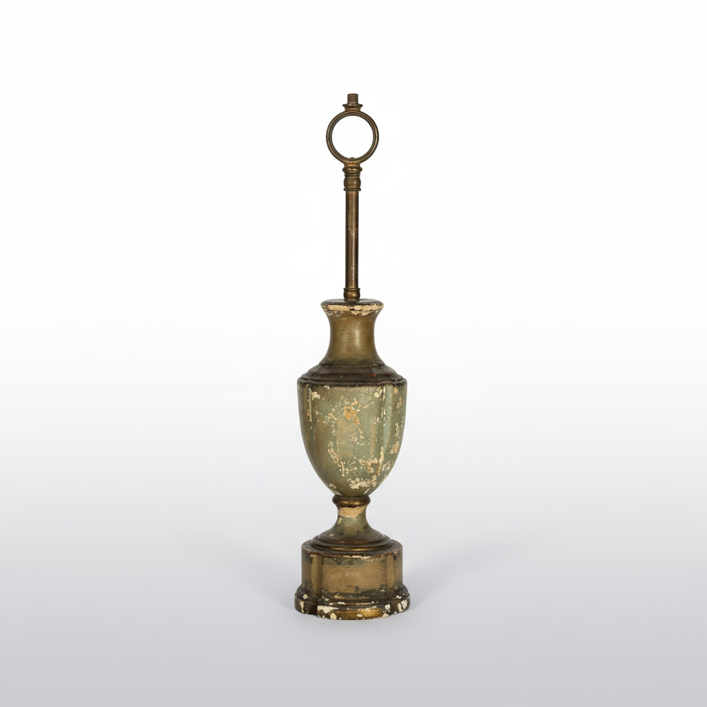 An antique-style metal urn-shaped object with a long vertical stem and circular top loop, shown on a dark background.