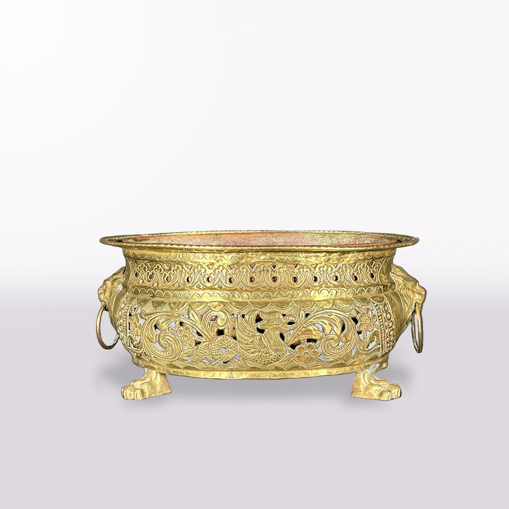 An ornate gold-toned metal incense burner with intricate filigree cutouts, lion-headed side handles, and three claw feet, shown on a plain light gray background.