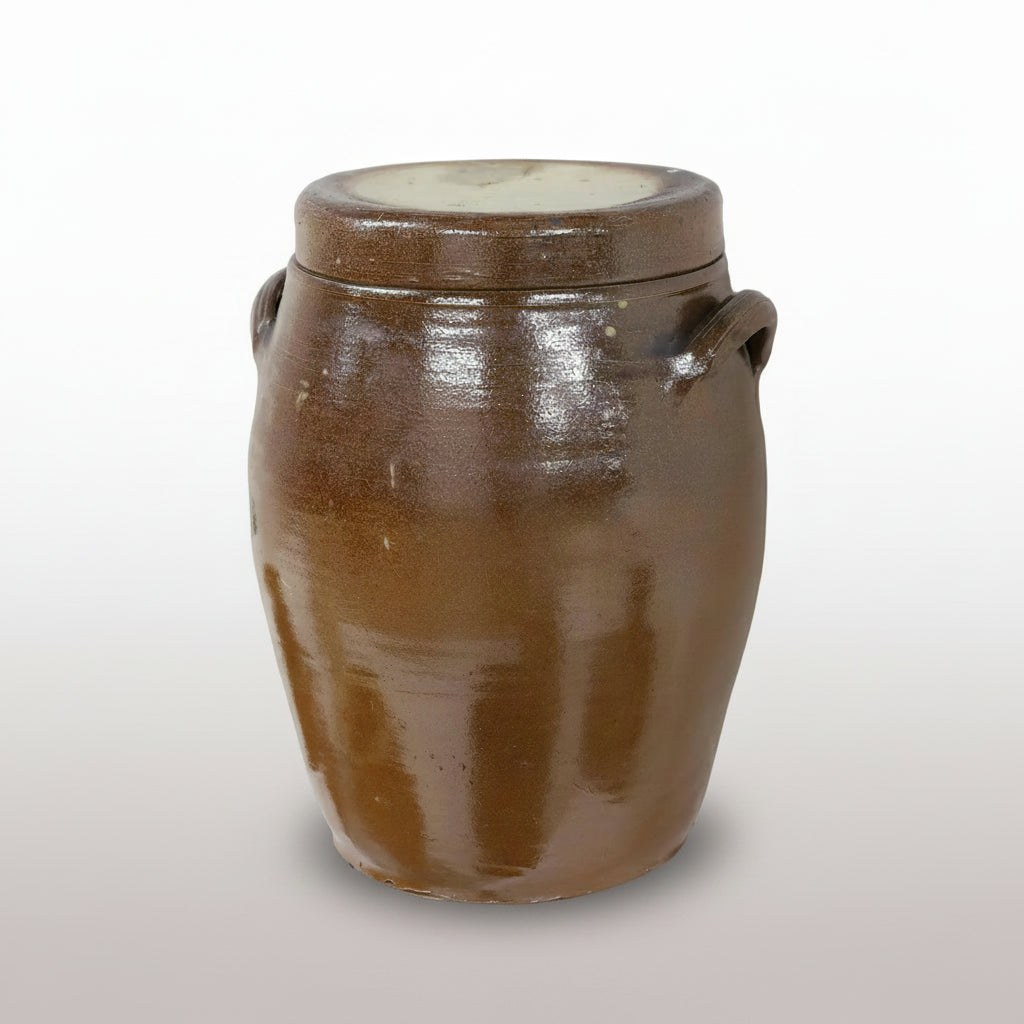 A French glazed stoneware confit jar with a domed lid and a pair of loop handles, in a rich brown glaze.