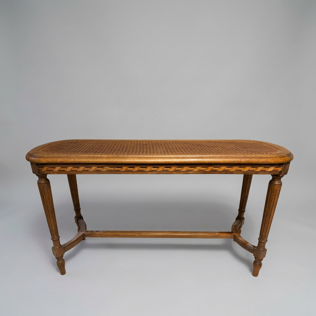 An antique wooden bench that features an elongated woven cane seat and geometric contrasting wood inlay along the apron.