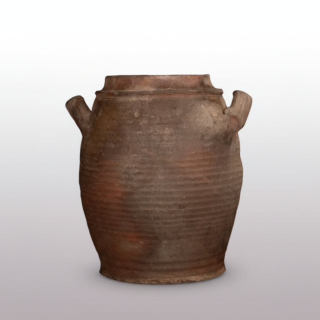 Vintage terracotta jar with ribbed texture on a dark background